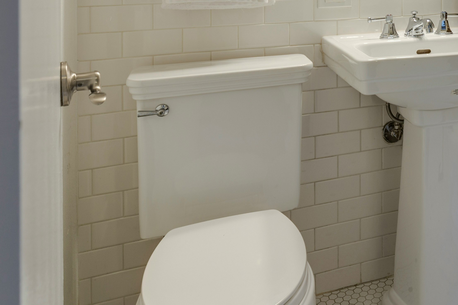 Toilette mit geschlossenem Spülkasten in einem hellen Badezimmer