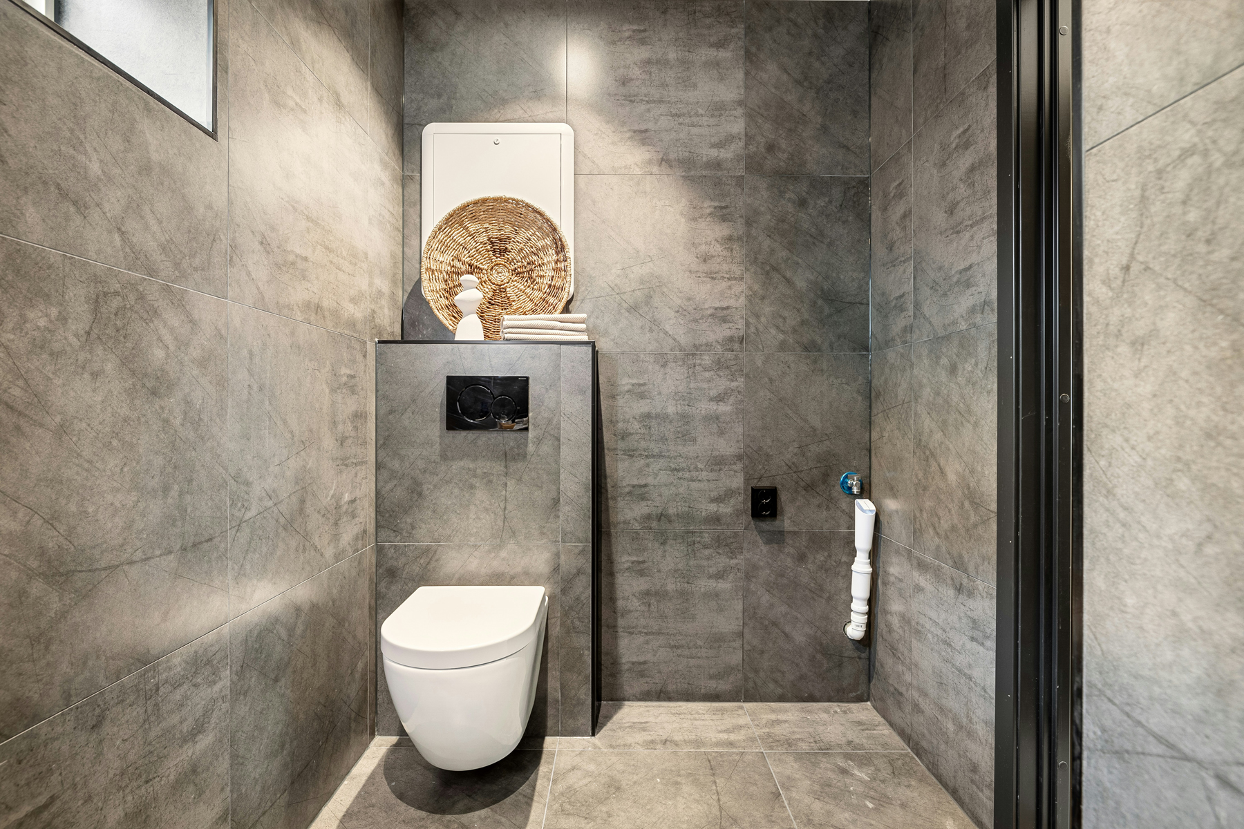 Wand-WC mit verdeckter Drückerplatte in modernem Bad